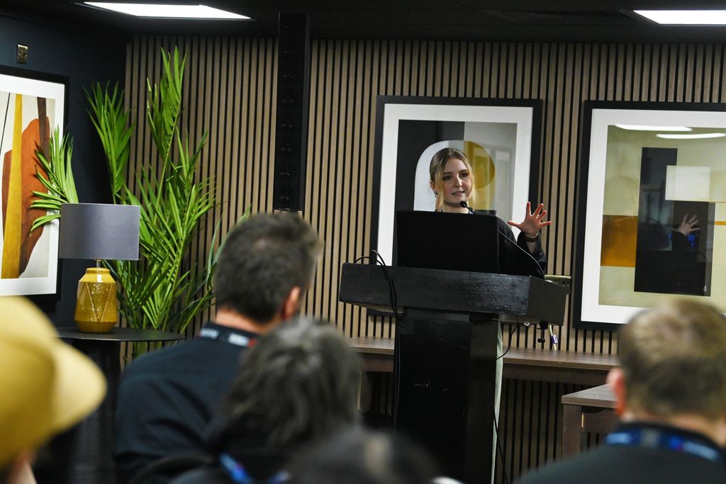 Female speaker delivers a seminar presentation to a seated audience at PLASA Focus Leeds