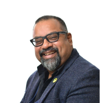 A man wearing a suit, smiling at the camera. 