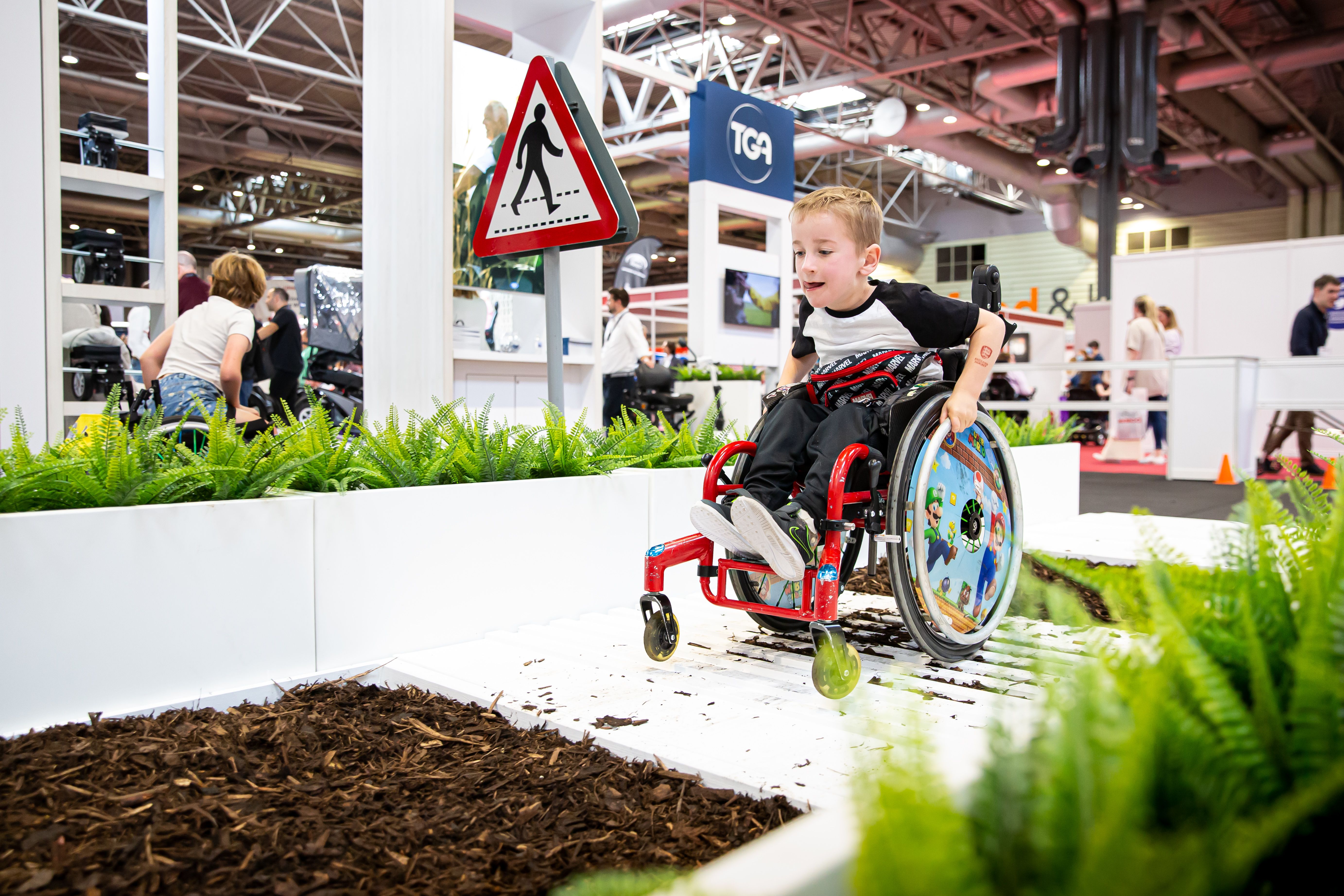 Naidex visitor having fun testing out wheelchair on the track