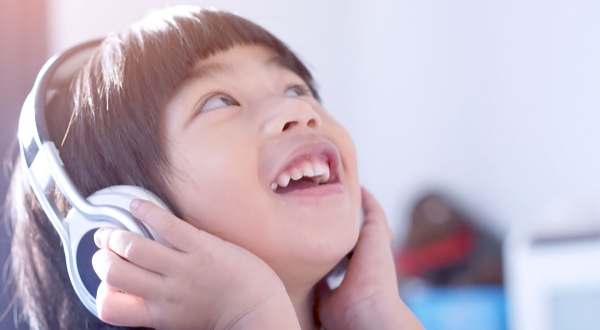 Child smile whilst listening to music with headphones on.