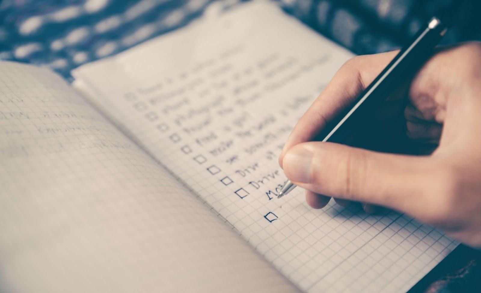 Picture of a person writing down a tick list.