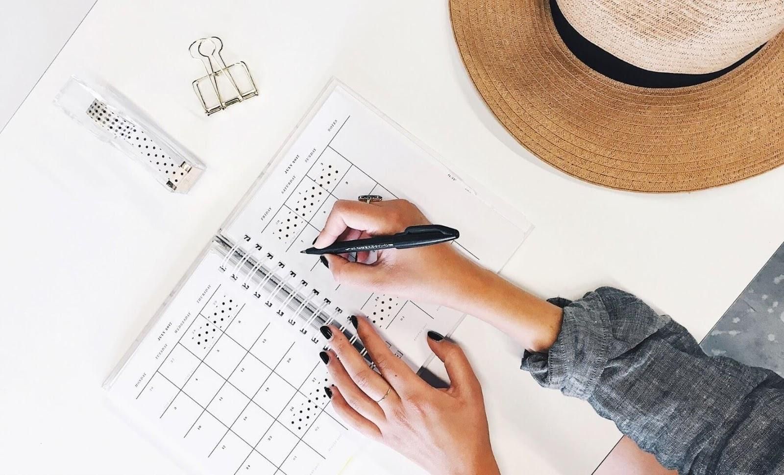 Image of a person taking notes on a diary planner