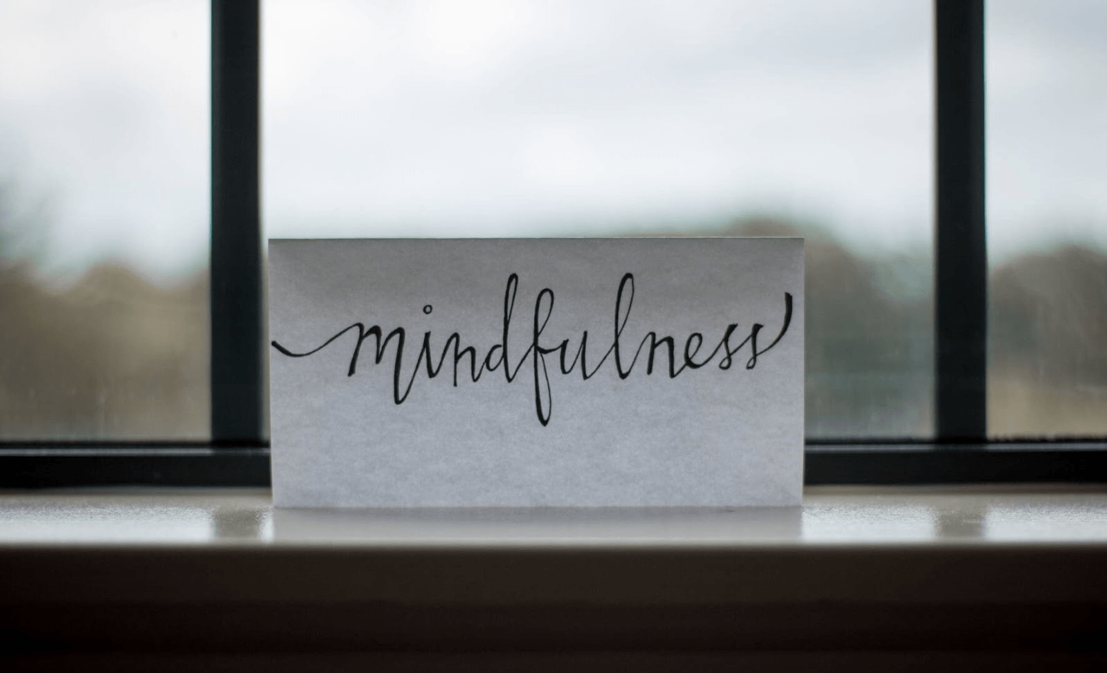 Picture of a white paper with the word mindfulness written on it in black.