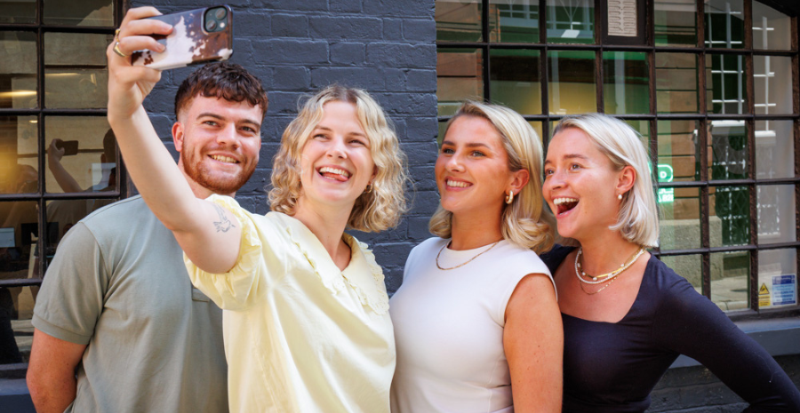 A man and three girls posing for a selfie
