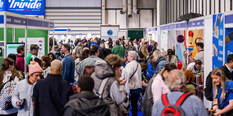 A busy aisle full of people at an exhibition