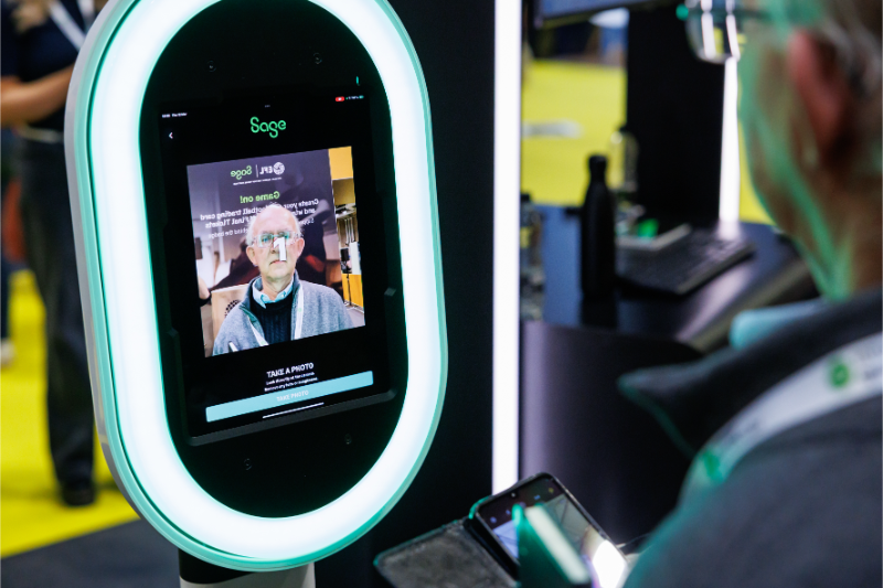 A person using a facial recognition kiosk labeled 