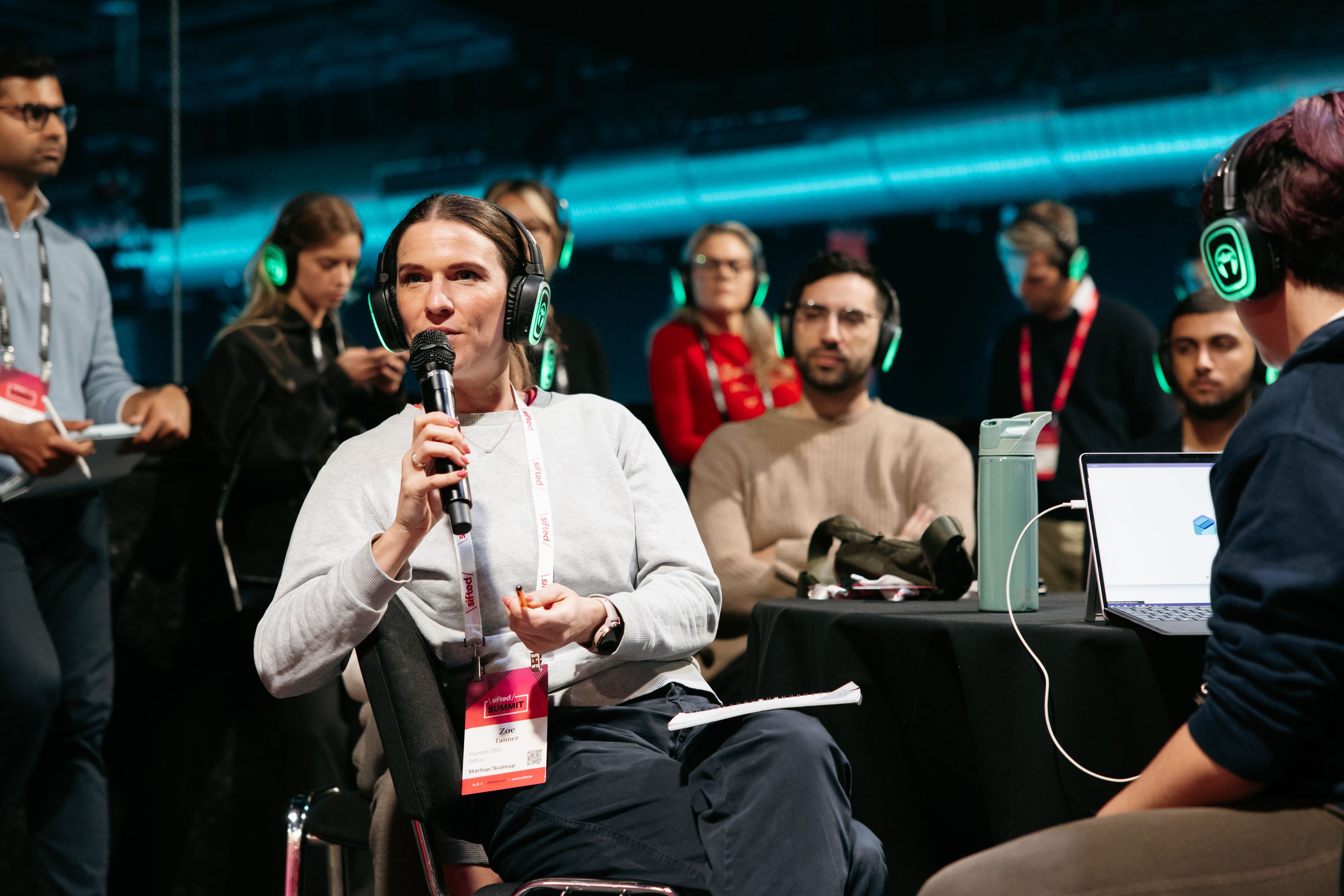woman speaking into a microphone from the audience at a Sifted Summit session
