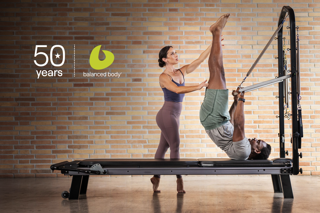 Pilates instructor with client on reformer