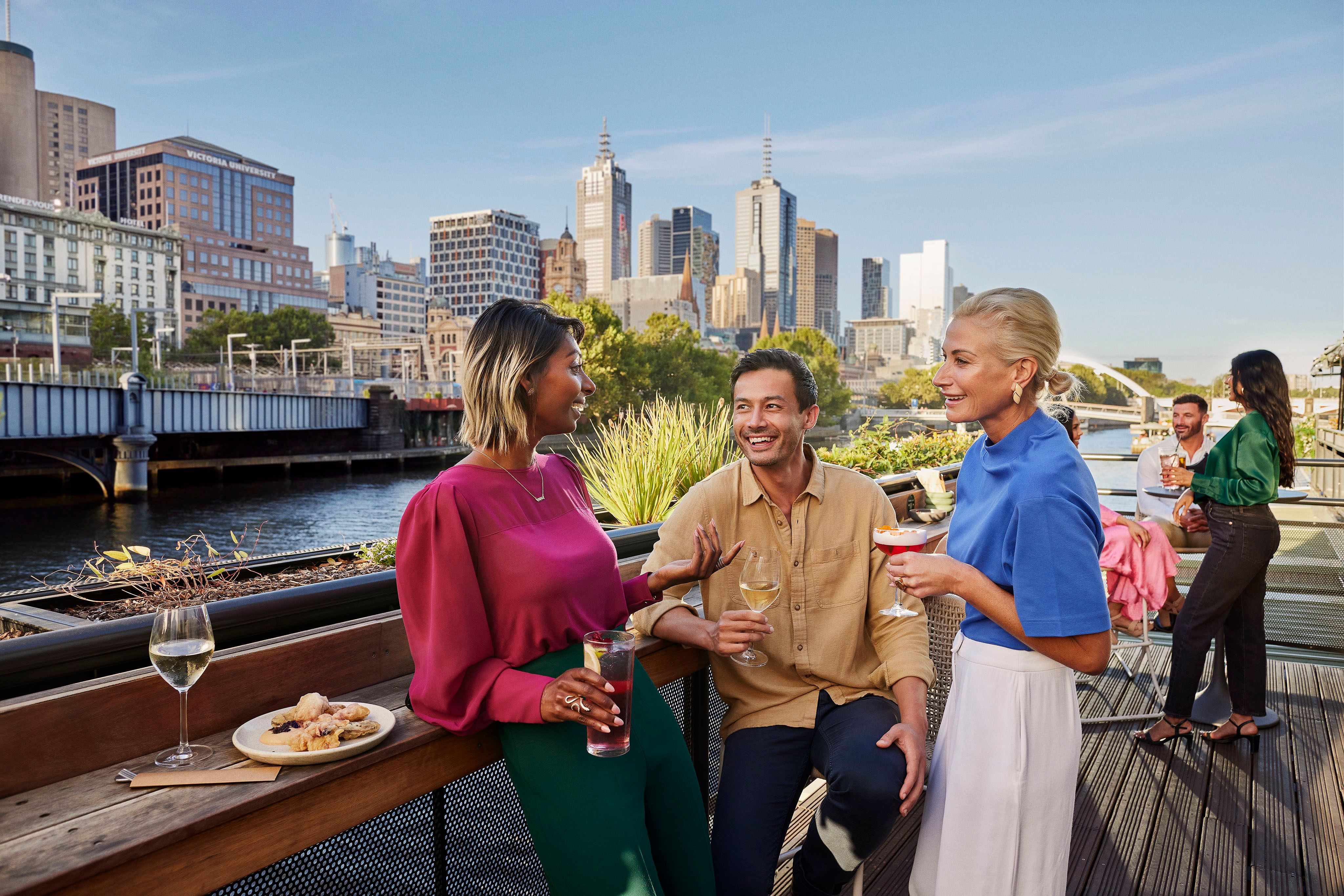 People dining and chatting near the Yarra river