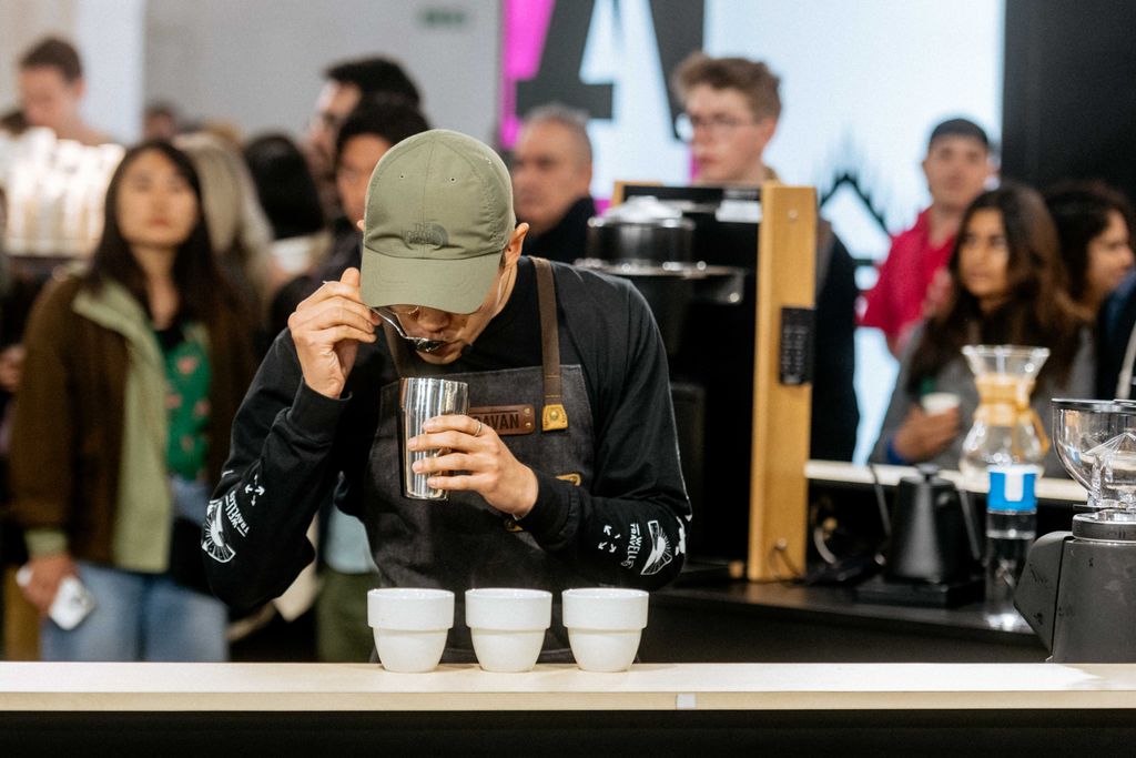 Person tasting coffee from cup