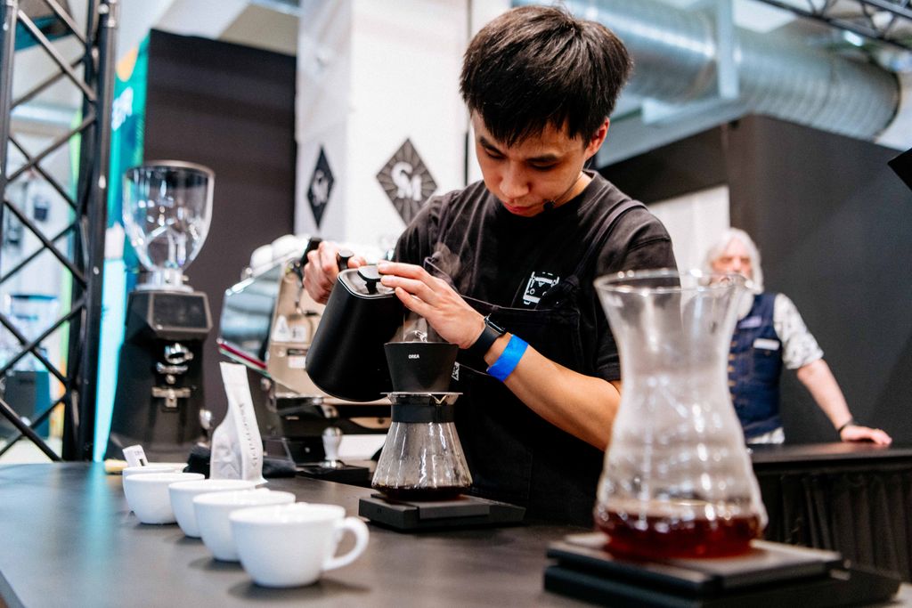 Man brewing coffee by pouring hot water over coffee granules 