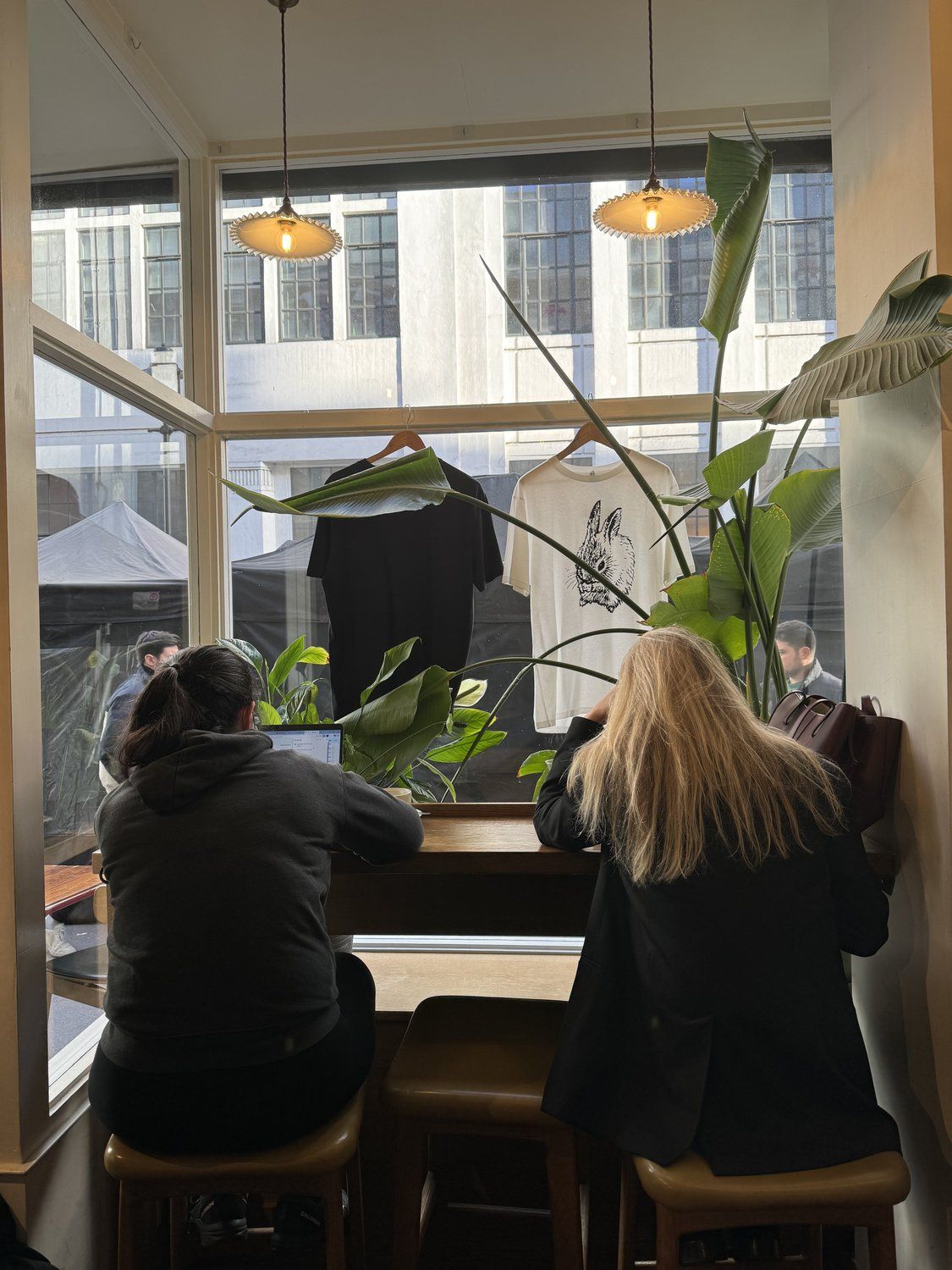 Customers working at a coffee shop window bar