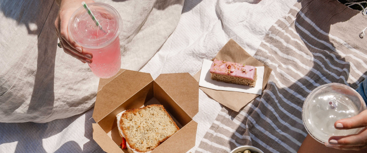 decent cups on picknick blanket with snacks