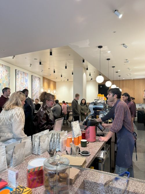 Customers queuing at a busy specialty coffee shop counter