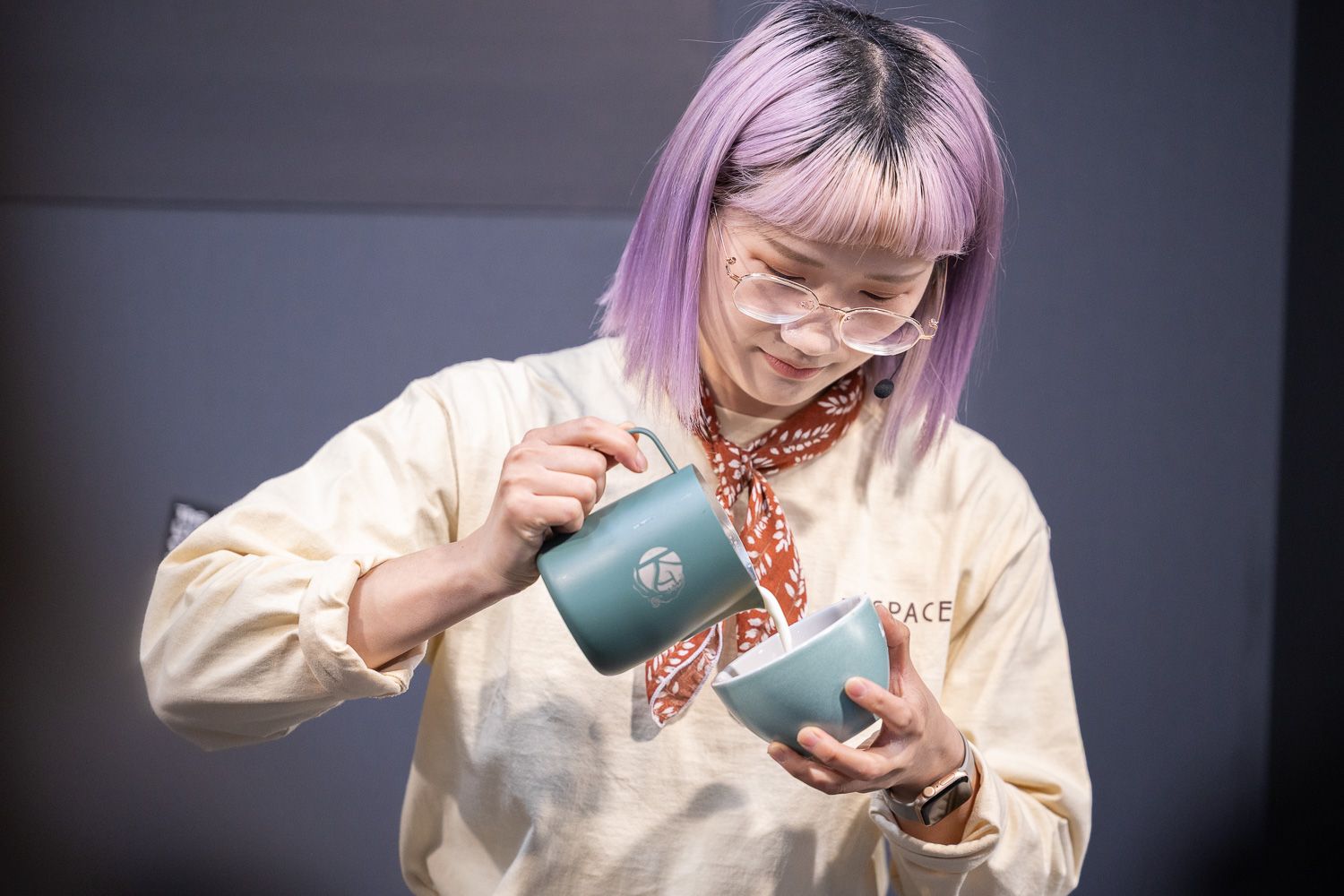 A barista pours from a jug into a cup during a demonstration at The London Coffee Festival